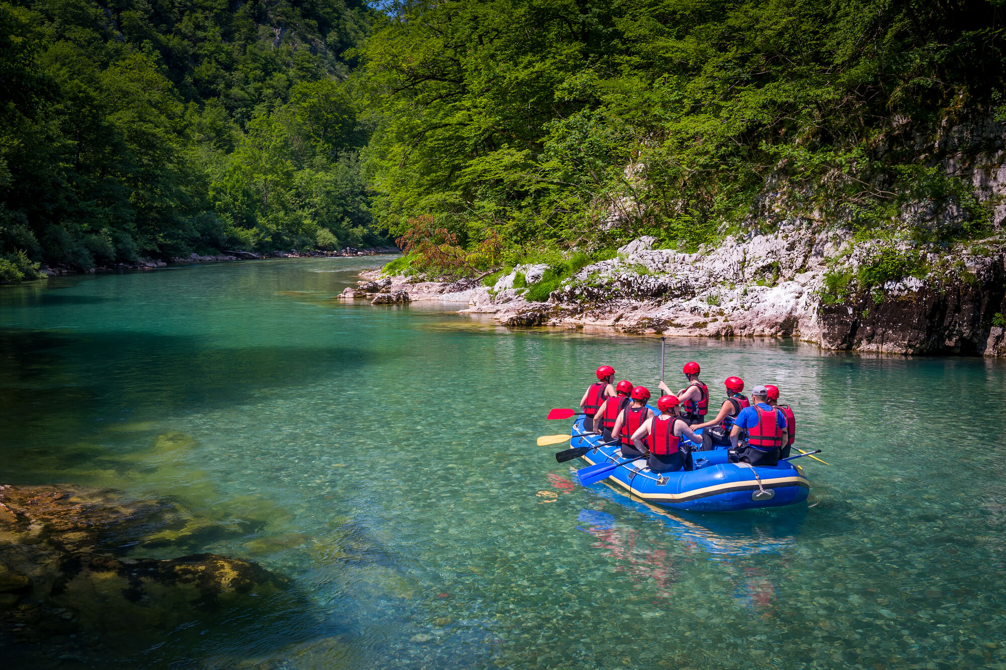 Rafting in the canyon of mountain river Tara. Group of tourists in the inflatable raft.